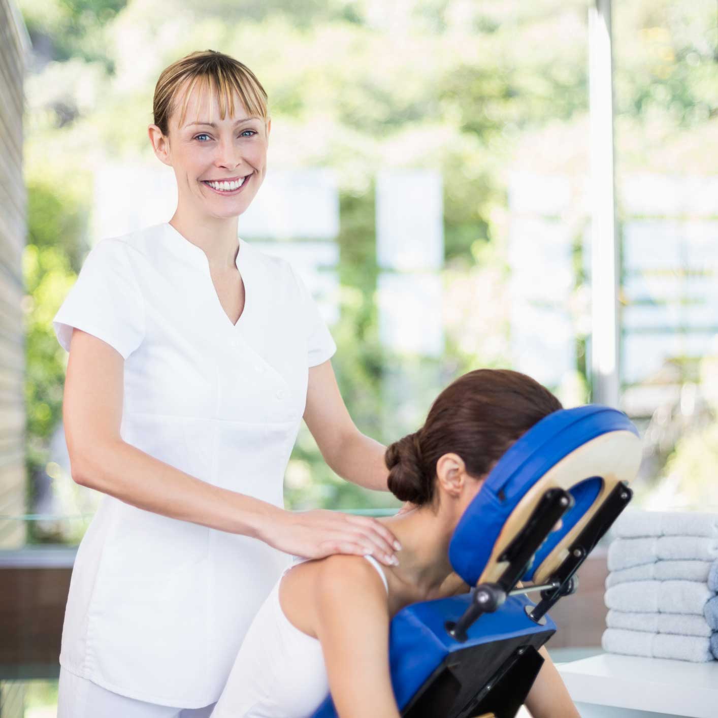 massage therapist massaging client in massage chair