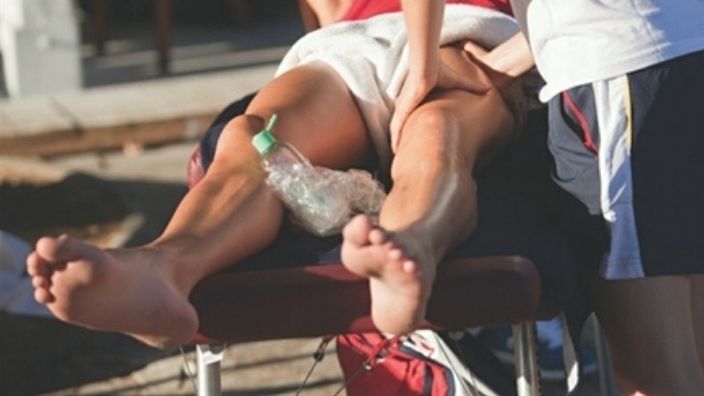 man receiving sports massage on leg