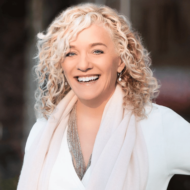 Close up photo of Allisson Massari, Headshot of woman with long, blonde, curly hair