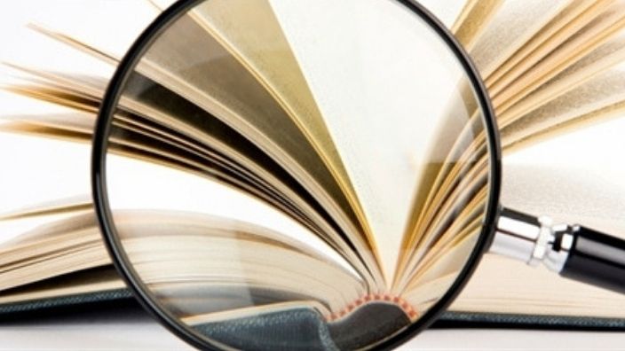 magnifying glass in front of open book