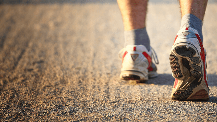 woman's feet running in gym shoes